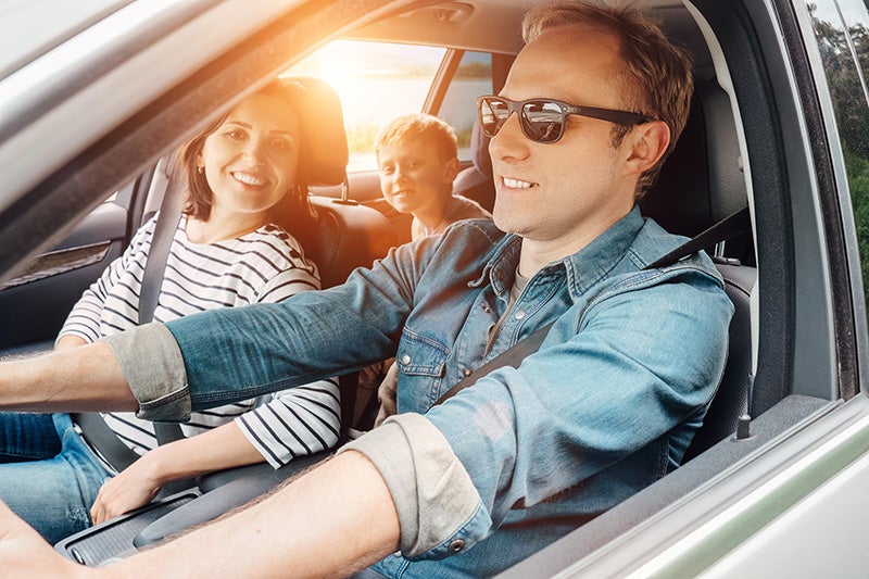 Family seated inside a vehicle while exploring affordable pre-owned car options at a dealership.